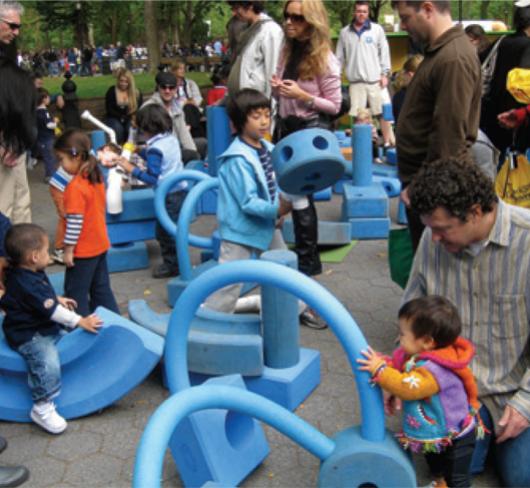 very young children playing in playground with adults