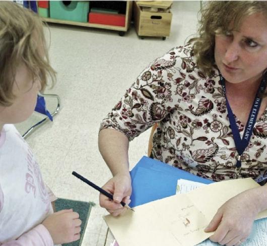 teacher working with kindergarten student