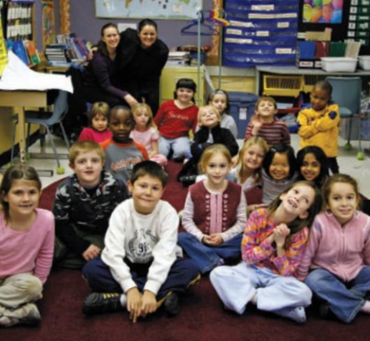 Young students sitting on carpet in classroom