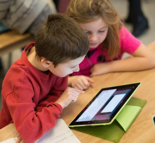 Two young students working with tablet