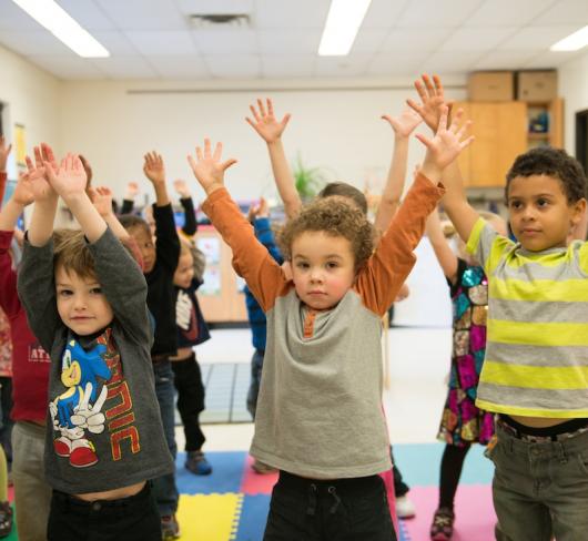 Young elementary students stretching in classroom