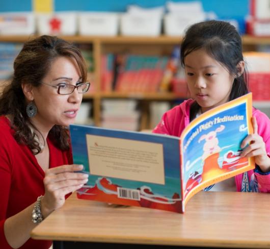 Teacher reading with elementary student