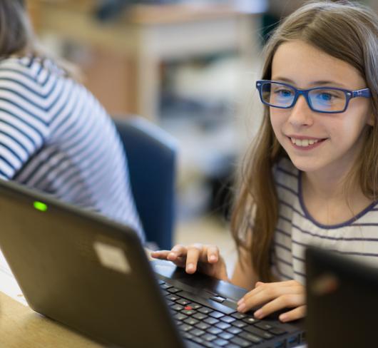 student using laptop and smiling